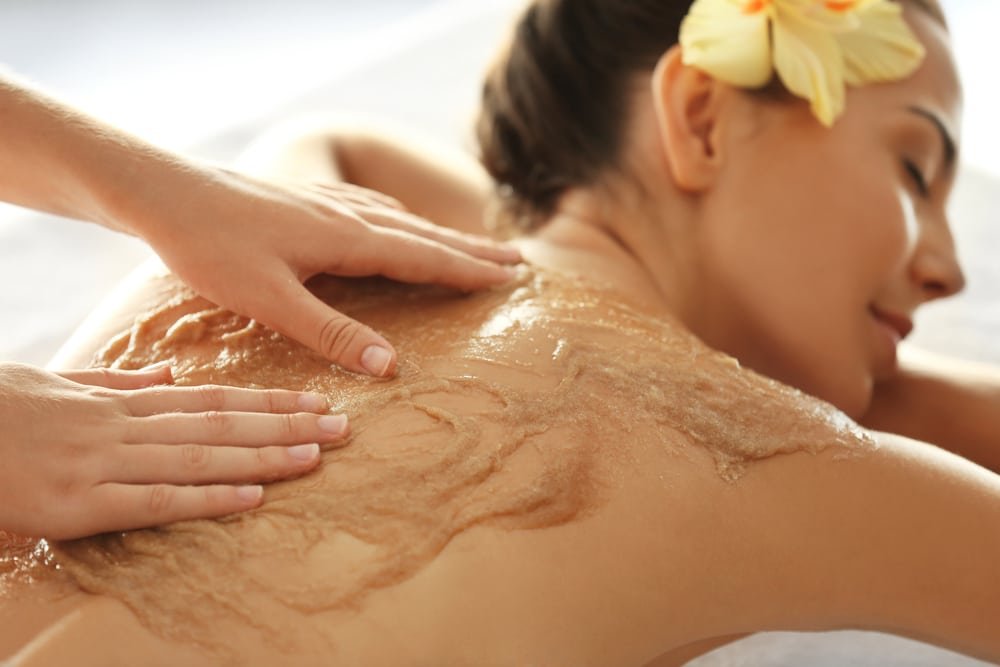 young,woman,receiving,scrub,massage,in,spa,salon
